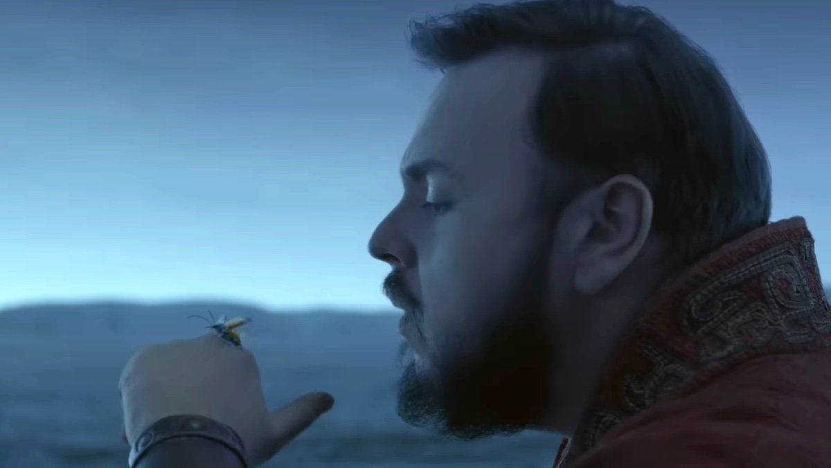 A man with a beard blows a winged insect off his hand in Netflix's 3 Body Problem