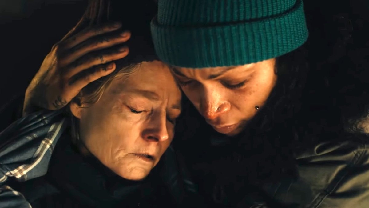 A woman in a green winter hat holds another sick woman's head on True Detective: Night Country, True Detective Night Country is a 2024 Emmy nominee 